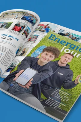 Energiejournal 2025 Ein geschlossenes Exemplar des Energiejournals Dezember 2025 liegt über einem aufgeschlagenen Exemplar